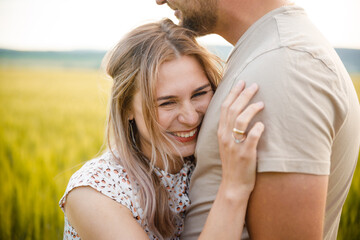 Loving couple on a green lawn. The girl smiles. Emotions.