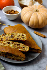Homemade sugar-free pie with pumpkin, almond flour, poppy seeds, raisins and honey, cut into pieces on a plate surrounded by ingredients, close-up. Healthy pumpkin cake. Keto diet, gluten free baked