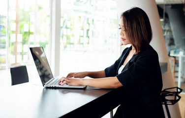 Portrait of Young asian businesswoman beautiful charming smiling and talking on the mobile phone in the office.Business people employee freelance online marketing e-commerce, work from home concept 