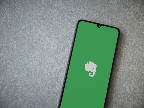 Lod, Israel - July 8, 2020: Evernote app launch screen with logo on the display of a black mobile smartphone on ceramic stone background. Top view flat lay with copy space.
