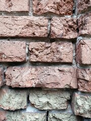 Light beautiful background and texture of stacked brown bricks wall with uneven seam on the right
