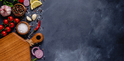 Fototapeta na wymiar Herbs and condiments on black stone background.