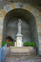 white marble statue under an archway 