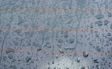 Water drops on the glass surface of the car against the background. Out of focus.