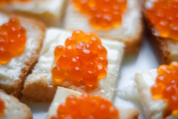 Background of bread and butter with red caviar.Sandwiches with butter and red caviar. Selective focus. Close-up. Background.