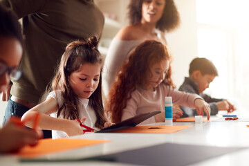 Group Of Children At Home With Parents Having Fun Making Craft Together