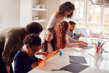 Group Of Children At Home With Parents Having Fun Making Craft Together