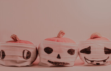 Halloween pumpkins in face masks with scary faces, covid quarantine concept photo.