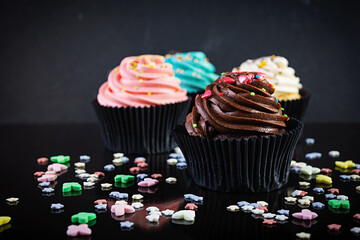 Tasty colorful cupcakes isolated on dark background. Delicious cupcake