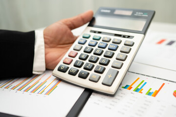 Asian accountant working and analyzing financial reports project accounting with chart graph and...