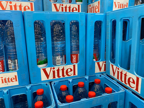 Viersen, Germany - July 9. 2020: View on isolated blue Vittel mineral water crates stacked in german beverage store (focus on central case)