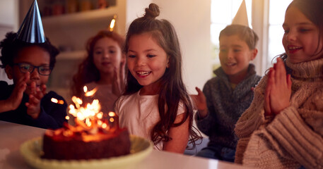 Girl Celebrating Birthday With Group Of Friends At Home Being Given Cake Decorated With Sparkler