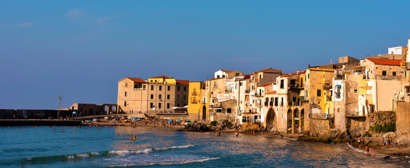 the village with its typical houses and bathers in the sea Cefalù Italy 