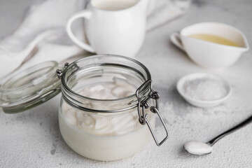 Vegan mayonnaise in a glass jar on a light background