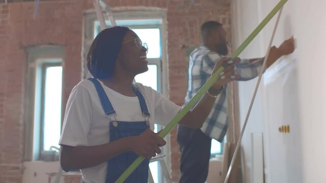 Side view of afro-american couple doing house renovation together