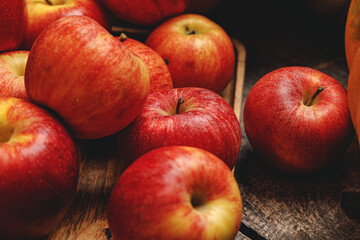 Pile of red apples on wooden table close up