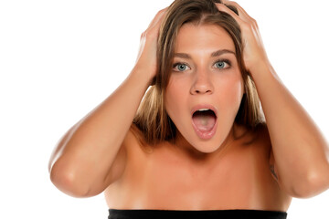 Portrait of beautiful young shocked woman on white background