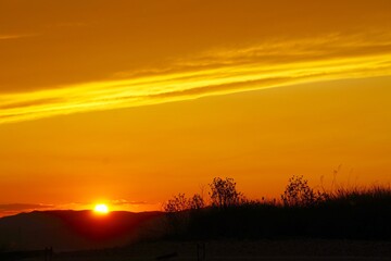 Obraz na płótnie Canvas Puesta de sol, cielo anaranjado, final del día
