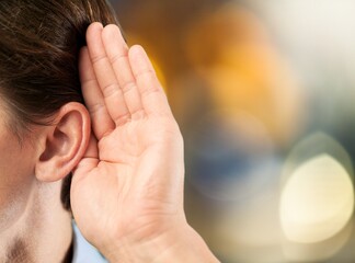 Human holds his hand near his ear and listening