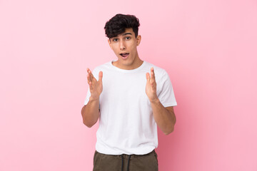 Young Argentinian man over isolated pink background with surprise facial expression