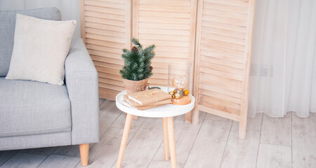 
Little christmas tree and books wrapped in gift paper on white table