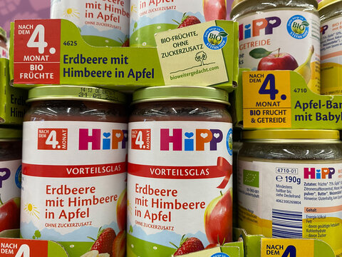 Viersen, Germany - July 9. 2020: View on isolated jars Hipp fruits food in shelf of german supermarket (focus on center)