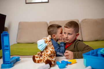 Children at home quarantine checking stuffed toy, for protection against viruses during coronavirus COVID-19 and flu outbreak. Children and illness disease concept.