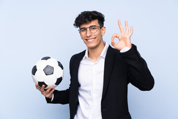 Argentinian Soccer coach over isolated blue background showing ok sign with fingers