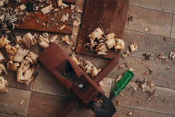 A hand planer and wood shavings on the tile floor
