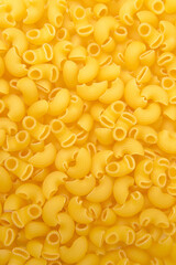 Background from macaroni pipa rigata. Raw, uncooked. Top view, close-up.