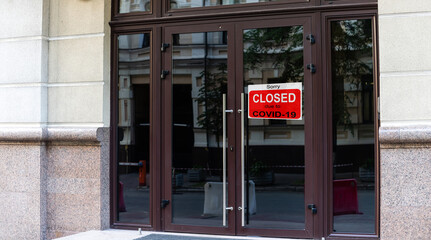 Business center closed due to COVID-19, sign with sorry in door window. Stores, restaurants, offices, other public places temporarily closed during coronavirus pandemic. Economy hit by corona virus