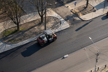 Asphalt road roller with heavy vibration roller compactor press new hot asphalt on the roadway on a road construction site. Heavy Vibration roller at asphalt pavement working. Repairing.