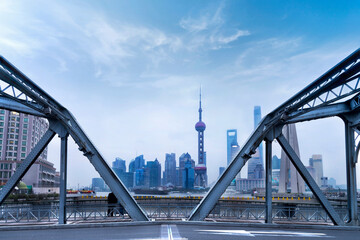 view of Shanghai cityscape with steel bridge structure frame, high rises office and towers of the Business district skyline at mist behind a pollution haze, across Huangpu river, Shanghai, China.