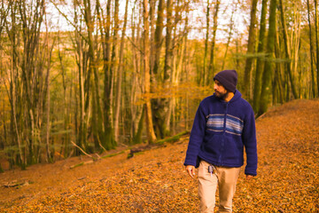 Lifestyle, a young man in a blue wool sweater enjoying the forest in autumn. Artikutza Forest in San Sebastián, Gipuzkoa, Basque Country. Spain