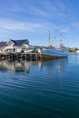 Fishing boats and wooden house on piles in small polar village Gjesvaer in the Northern Norway,...