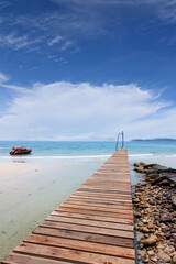 Fototapeta na wymiar Wooden bridge, corridor to the sea on Beautiful crystal clear sea and tropical beach at tropical paradise island, Thailand