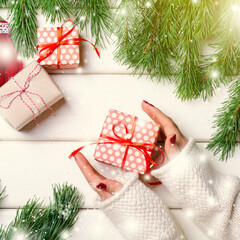Female hands holding Christmas gift box on whitr background. Horizontal, copy space.