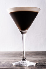 Martini espresso cocktail in glass on wooden table