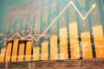 Financial graph colorful drawing and table with computer on background. Double exposure. Concept of international markets.