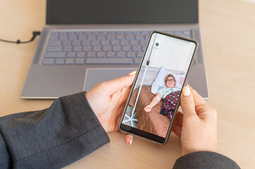 Business woman makes a video call on a smartphone to a sick elderly mother in a hospital