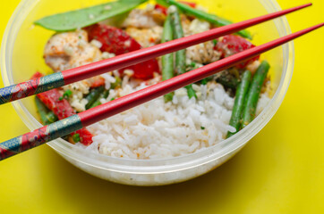 Cooked chicken breast pieces in a red Thai curry sauce made with coconut cream, red chillies, lemongrass, lime leaf, with fragrant rice, red peppers, mangetout, and green beans