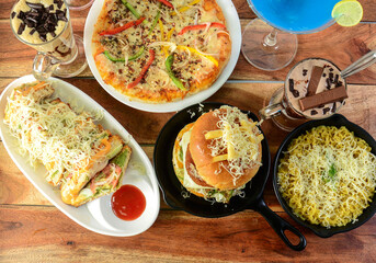 Assorted foods cheese grilled sandwich,paneer cheese burger,cheese maggie and capsicum pizza on...