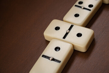 Close-up of matching dominoes or domino tiles on wooden table seen from above. Detail of game. Educational games, development and indoor activities concepts