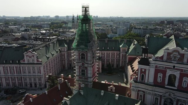 Church under construction and colorful houses in old Town Hall in Poznan, Poland. Drone shot of church Fara Poznańska under construction. Main Square in the Poznan Old Town.