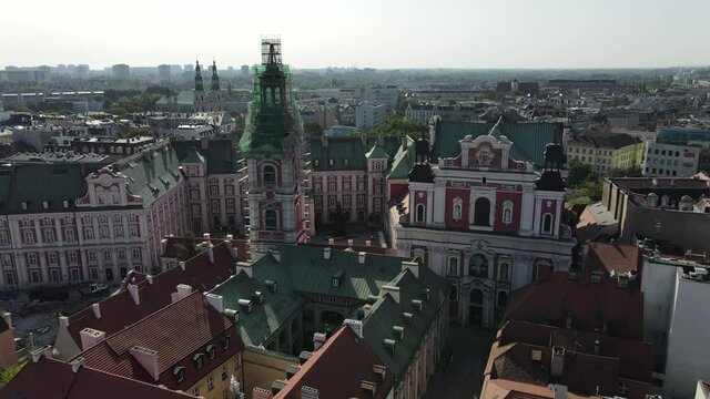 Drone shot of front view of Fara Poznańska. Church under construction and colorful houses in old Town Hall in Poznan, Poland. Main Square in the Poznan Old Town. Aerial view on Poznan main square.