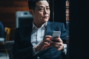 Serious business man using smartphone in cafe 