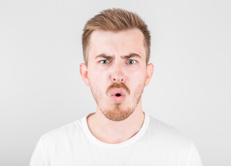 Obraz premium Surprised young guy is posing in studio on white background