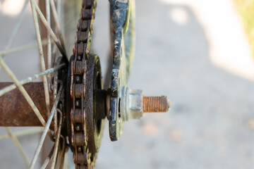 Close-up of old rusty chain from bicycle in the background, detail view of bicycle wheels.