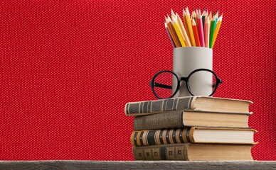 Stack of vintage books and colorful pencils on the desk