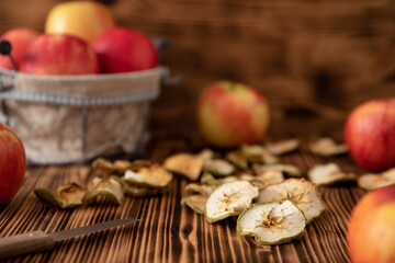 Naklejka na ściany i meble Apfel in Scheiben geschnitten und getrocknet im Herbst für den Winter als Vorrat auf einem Tisch aus Holz
